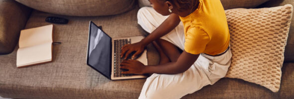 The woman is typing on a laptop