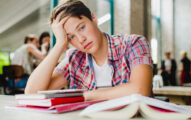 Exhausted student is sitting at the table