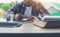 A student is writing on a notepad