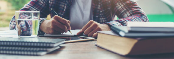 A student is writing on a notepad