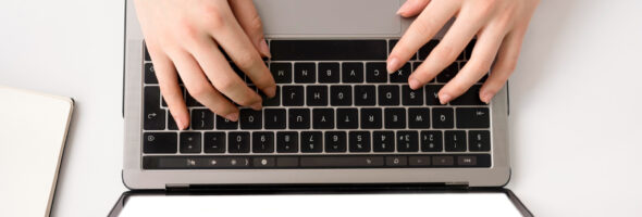 Top view of hands typing on the laptop.
